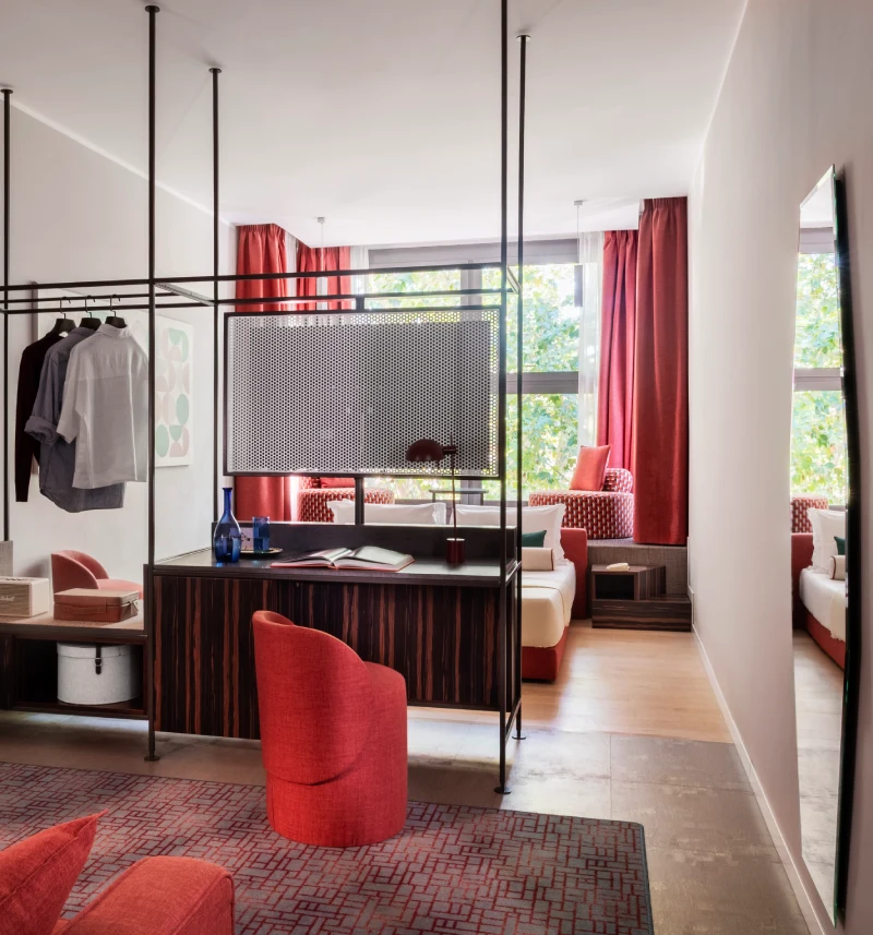 Suite living area with red sofa, desk and open wardrobe - Parioli Cube Hotel, BZAR hotels in Rome